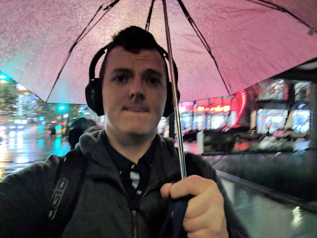 It's dark, I'm under a pink umbrella heading to the Airbnb.
