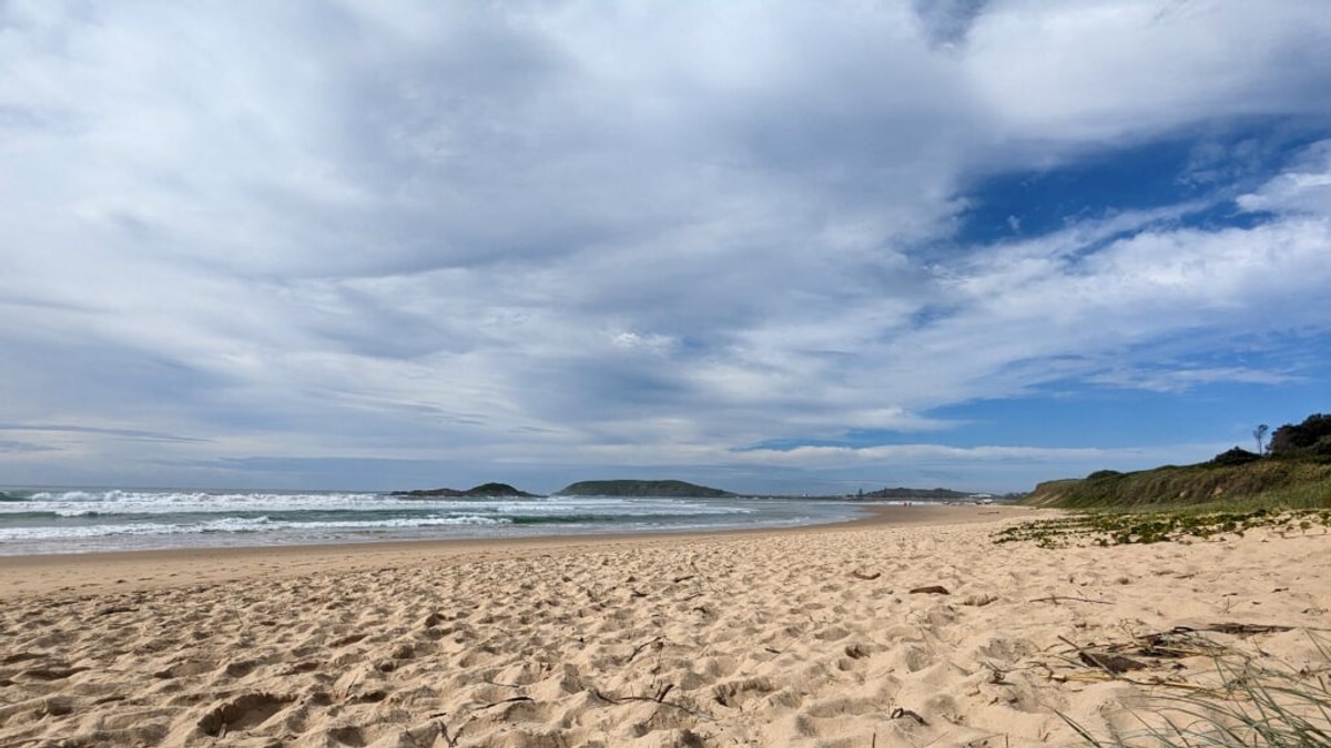 Overcast with patches of blue sky over Park Beach. Muttonbird Island in the distance.