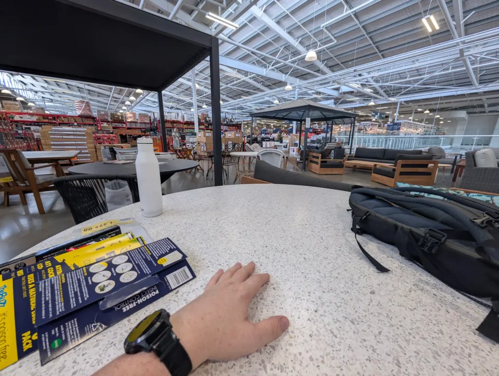 We're in Bunnings. The place is enormous. My hand rests contentedly on a round terrazzo concrete table, with a backpack, water bottle, and a bunch of sticky cockroach things scattered around. This actually isn't actually my table, but it's similar.