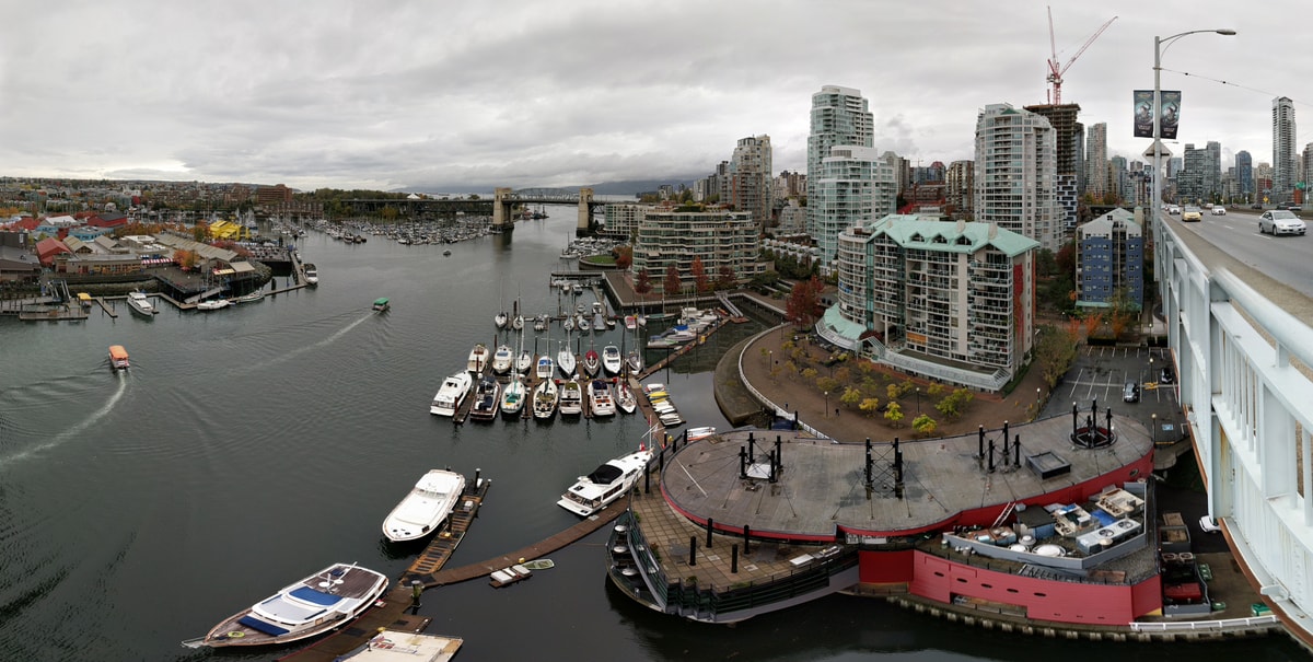 Looking out from the Granville Bridge. There's iconic Vancouver highrises on one side and boats zipping about the water.