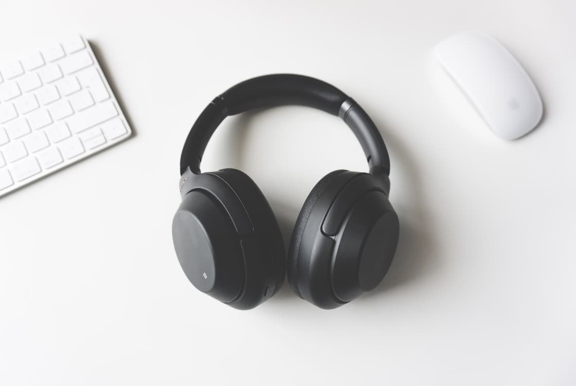 A pair of Sony headphones sit on a desk